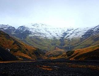 Snow-capped mountain range in Akranes, showcasing the beauty of nature's peaks against a clear blue sky