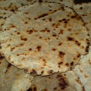 Close-up of bhakri flatbreads layered on top of one another, showcasing their texture and golden-brown color
