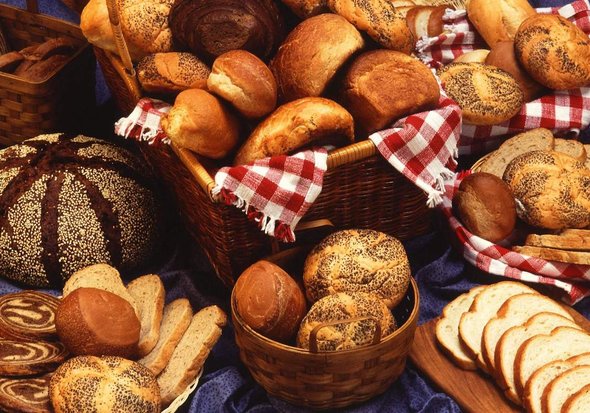 A selection of various breads elegantly arranged on a table, showcasing different shapes and textures