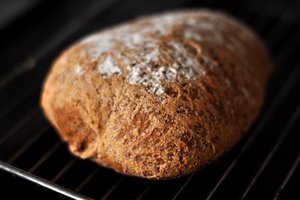 A loaf of Olandshvedebrod resting on a cooling rack, showcasing its golden crust and inviting texture